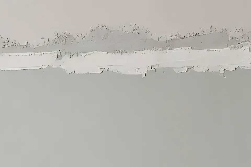 Close-up of a taped drywall seam with joint compound along the top of a wall.