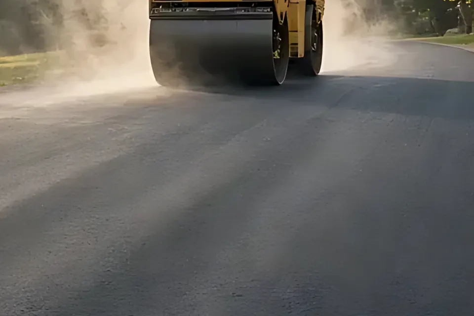 Close-up of the edge where fresh asphalt meets a gravel shoulder.