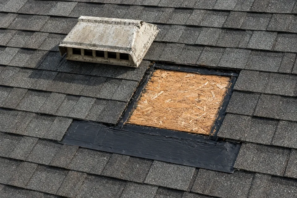Upper roof opening from a removed static box vent patched with fresh plywood and underlayment.
