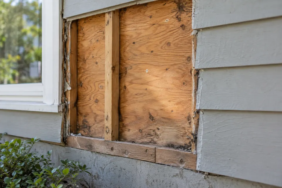 Siding planks removed during tear-off to inspect OSB wall sheathing and framing studs.